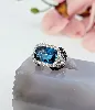 bague cocktail centrée d'une topaze facetée serti clos entourée de petits diamants et de saphirs sur le panier or 750 millième (18