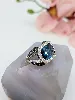 bague cocktail centrée d'une topaze facetée serti clos entourée de petits diamants et de saphirs sur le panier or 750 millième (18