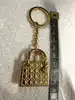 bijou de sac/porte-clés christian dior lady dior en métal doré, motif cannage