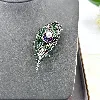 broche motif plume pavée d'oxydes en acier