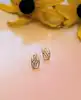 boucles d'oreilles en 2 ors motifs ajourés centrée d'une ligne de petits diamants or 375 millième (9 ct) 0,76g