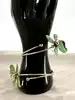 bracelet de bras ouvert en métal doré er motif fleurs en émail vert