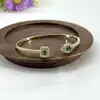bracelet jonc ouvert avec oxydes verts et blancs en métal doré