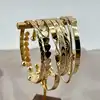 bracelet semainier 7 joncs ouverts en acier doré