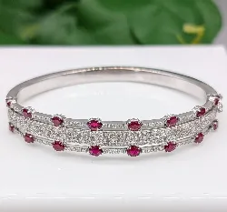 bracelet jonc ouvrant orné de 16 rubis ovale et des lignes de diamants d'environ 2,8ct au total  or 750 millième (18 ct) 34,86g