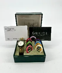 montre gucci play 1100l cadran blanc et boîtier et bracelet rigide en métal doré avec 12 lunettes interchangeables, muvement à qua