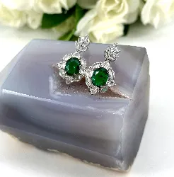 boucles d'oreilles style art-déco pendantes chacune centrée d'une pierre verte entouré d'oxydes