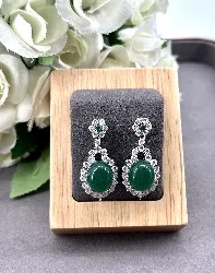 boucles d'oreilles style art-déco pendantes chacune centrée d'une pierre verte entouré d'oxydes