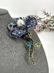 broche fleur en métal doré ornée des strass colorés centrée d'une perle synthétique
