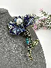 broche fleur en métal doré ornée des strass colorés centrée d'une perle synthétique