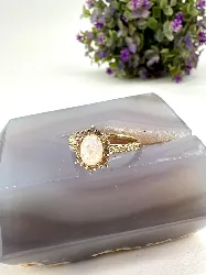 bague centrée d'une pierre de lune entourée d'oxydes en méral doré t59