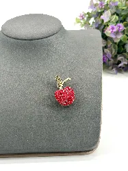 broche en forme d’pomme pavée d’oxydes en métal doré