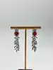 boucles d'oreilles pendantes chacune avec d'une pierre rouge