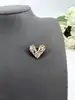 broche coeur pavé d'oxydes en métal doré