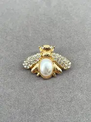 broche motif abeille en métal doré, sertie d’une perle synthétique et d’oxydes