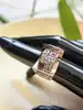 bague tank avec une pavage d'oxydes et pierres rouges surmontée sur une face creuse en or rose 18k argent 800 millième (19 ct) 11,