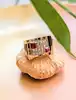 bague tank avec une pavage d'oxydes et pierres rouges surmontée sur une face creuse en or rose 18k argent 800 millième (19 ct) 11,