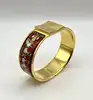 bracelet jonc hermès en émail, orné d'un motif de chevaux rouges, avec finition plaquée or