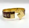 bracelet jonc hermès en émail, orné d'un motif de chevaux rouges, avec finition plaquée or