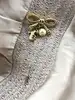 broche épingle salvatore ferragamo noeud en métal doré