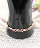 bracelet articulé en 2 ors orné des motifs fleur en rubis et motifs x chacun serti d'un diamant or 750 millième (18 ct) 10,90g