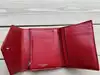 portefeuille yves saint laurent en cuir rouge matelassé grain de poudre avec logo argenté