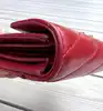 portefeuille yves saint laurent en cuir rouge matelassé grain de poudre avec logo argenté
