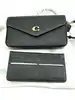 sac bandoulière coach wyn en cuir noir grainé, avec une poche amovibles plate avec 6 fentes