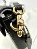 sac bandoulière coach wyn en cuir noir grainé, avec une poche amovibles plate avec 6 fentes