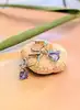 boucles d'oreilles dormeuses en or blanc chacune sertie d'une tanzanite forme poire surmontée d'un diamant taille brillant or 750 