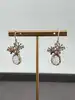 boucles d'oreilles pendantes chacune avec d'une pierre rose