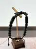 bracelet en cordon orné d’un onyx, avec deux têtes de léopard pavées d’oxydes