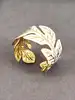 bracelet manchette motif feuille en émail blanc et en métal doré