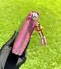 portefeuille zippé gucci en cuir verni rose avec pendentif bambou