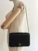 sac pochette coach en cuir grainé noir, chîne dorée détachable