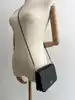 sac pochette coach en cuir grainé noir, chîne dorée détachable