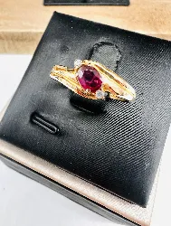 bague ornée d'un rubis forme ovale épaulé de 2 petits oxydes or 750 millième (18 ct) 1,49g