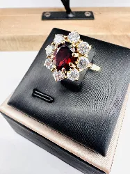 bague maguerite centrée d'une pierre rouge entourée de 8 oxydes or 750 millième (18 ct) 4,10g