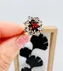 bague maguerite centrée d'une pierre rouge entourée de 8 oxydes or 750 millième (18 ct) 4,10g