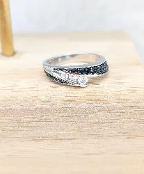 bague croisée en or blanc centrée de 3 diamants blanc d'environ 0,20cts épaulés des lignes de diamants noirs or 750 millième (18 c