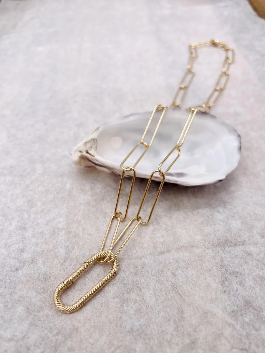 Collier en acier doré à grosses mailles et orné de breloques