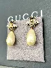 boucles d'oreilles pendantes gucci en métal or vieilli logo gg motif abeill et perle synthétique en forme goutte d'eau style baroq