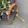 bracelet guess en acier doré et cuir orange orné d'un coeur en strass