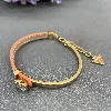 bracelet guess en acier doré et cuir orange orné d'un coeur en strass