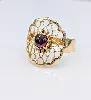 bague fleur motifs vidés centrée d'une pierre de grenat en cabochon or 750 millième (18 ct) 2,30g