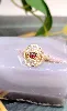 bague fleur motifs vidés centrée d'une pierre de grenat en cabochon or 750 millième (18 ct) 2,30g