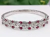 bracelet jonc ouvrant orné de 16 rubis ovale et des lignes de diamants d'environ 2,8ct au total  or 750 millième (18 ct) 34,86g