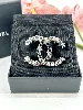 broche chanel cc en métal gris et noir avec des strass