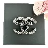 broche chanel cc en métal gris et noir avec des strass