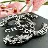 broche chanel cc en métal gris et noir avec des strass